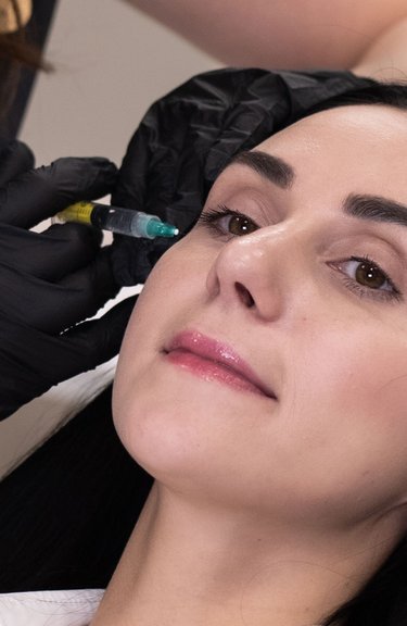 Косметолог виконує інʼєкції під час корекції зони навколо очей