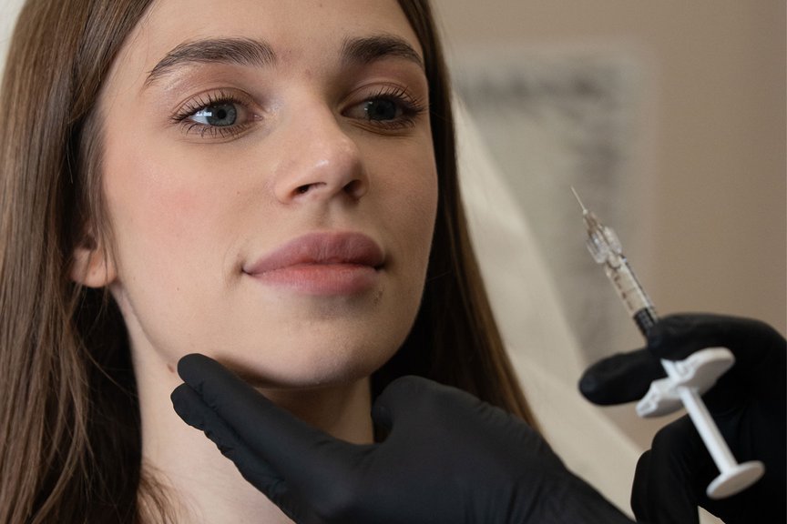Косметолог виконує інʼєкції під час контурної пластики обличчя