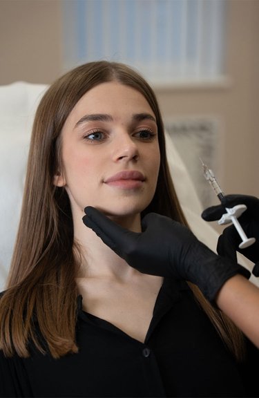 Косметолог виконує інʼєкції під час контурної пластики обличчя