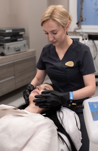 Косметолог проводить процедуру мікрострумової терапії обличчя